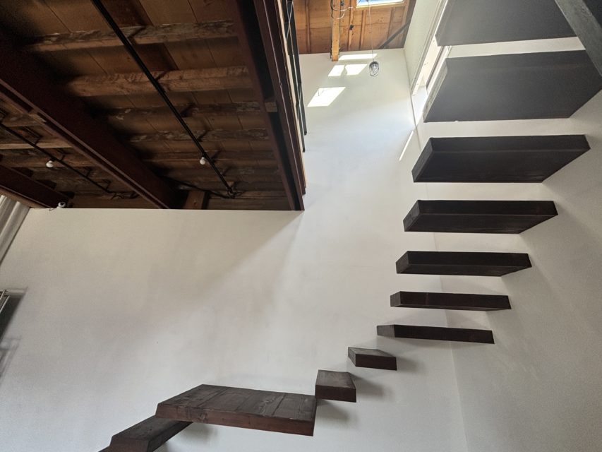 2月の低い太陽光が吹き抜けの天窓から差し込む様子。スタジオフィールドの白い壁と木の天井に、冬特有の短い光が落ちる幻想的な内観写真。